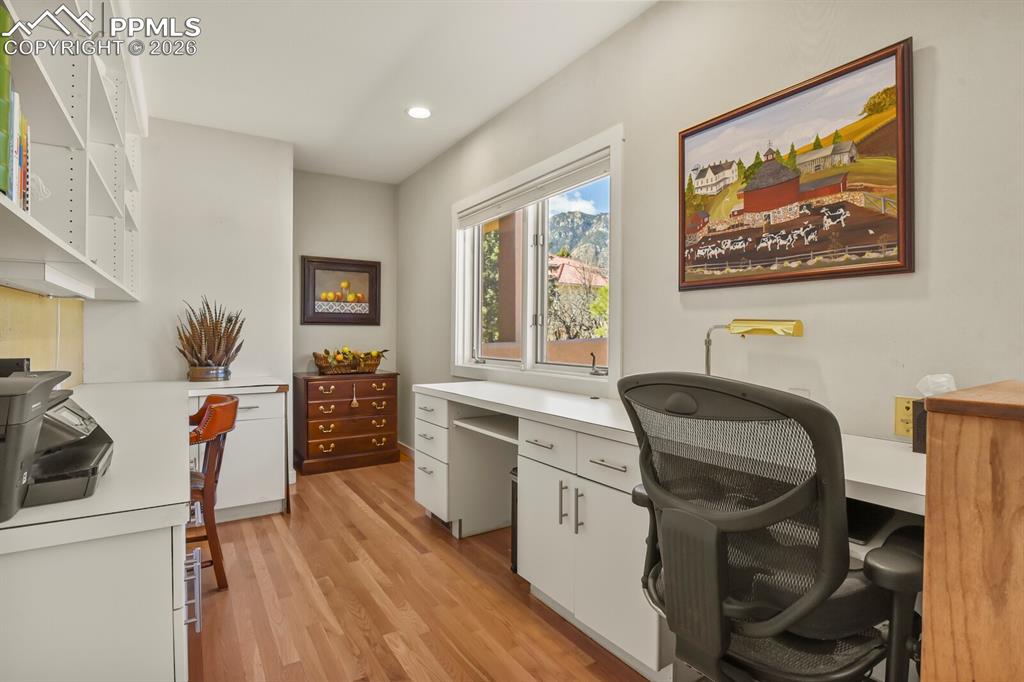 Image 20 of 50: Dedicated office space open to the kitchen, with cabinets and shelvings for