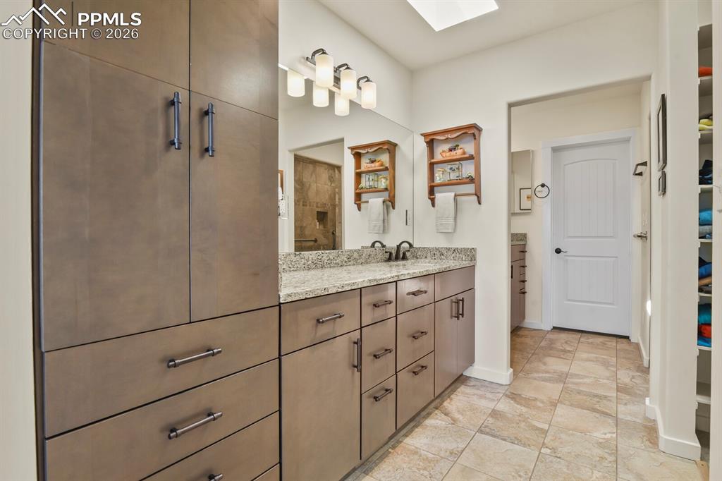 Image 29 of 50: Another view of the Primary Bathroom showing one of the two vanities and al