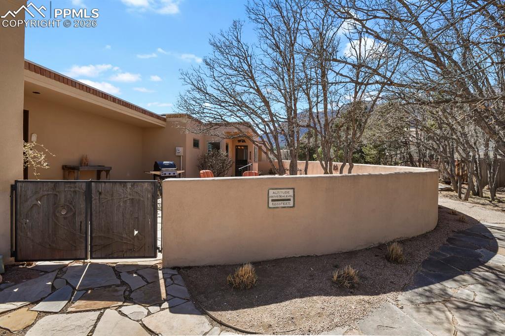 Image 3 of 50: View of property exterior of this stucco ranch home, showing the walled and
