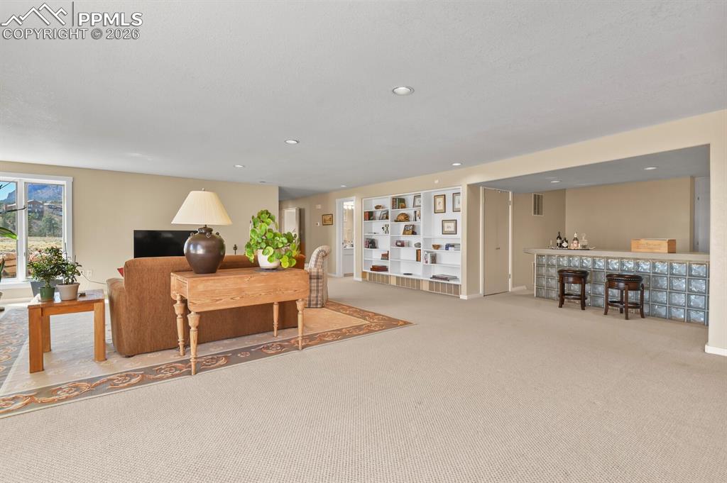 Image 33 of 50: Another view of the Second Family Room, showing the bar area and the shelvi