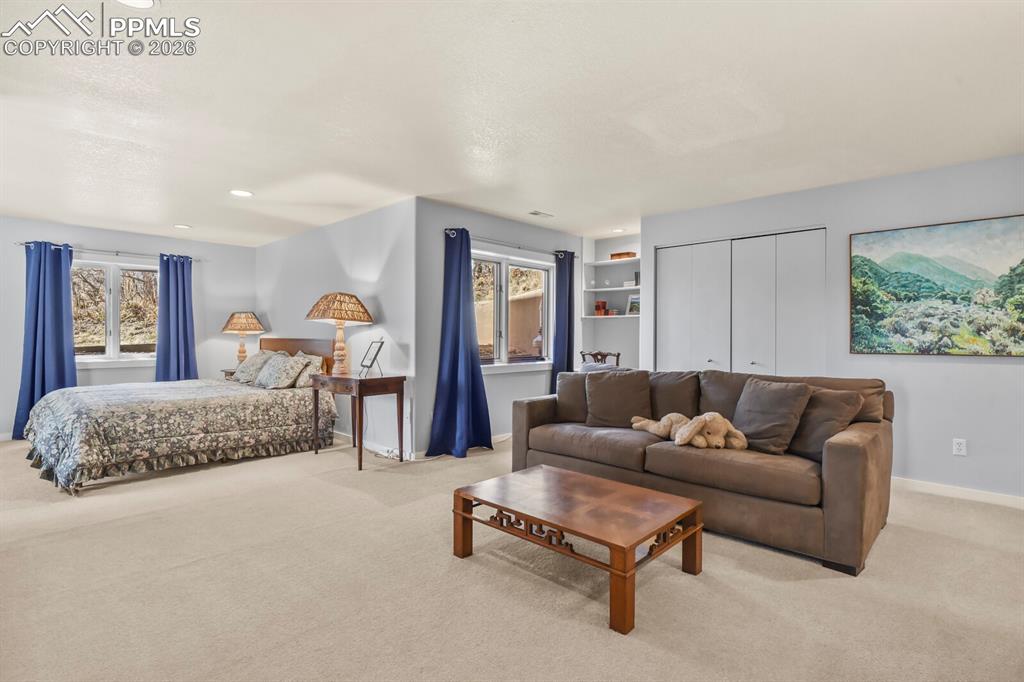 Image 36 of 50: This is a second bedroom suite, with a sitting area, lots of windows, shelv