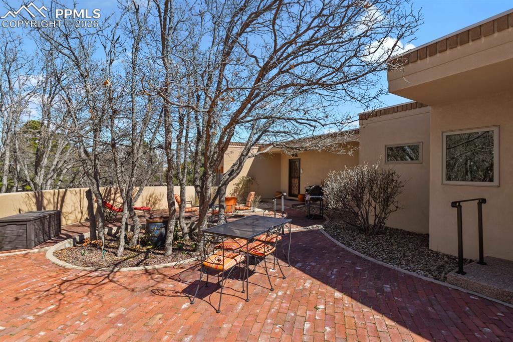 Image 6 of 50: Walled paved and landscaped patio area.