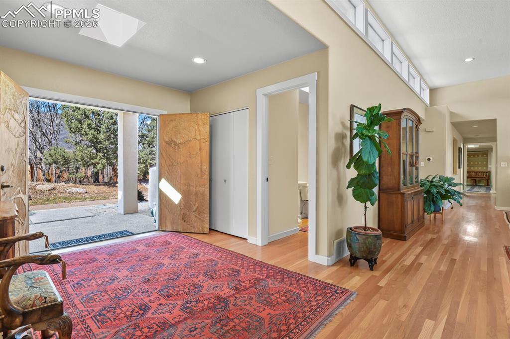 Image 7 of 50: Covered porch area, double doors, enter into the foyer with hardwood floors