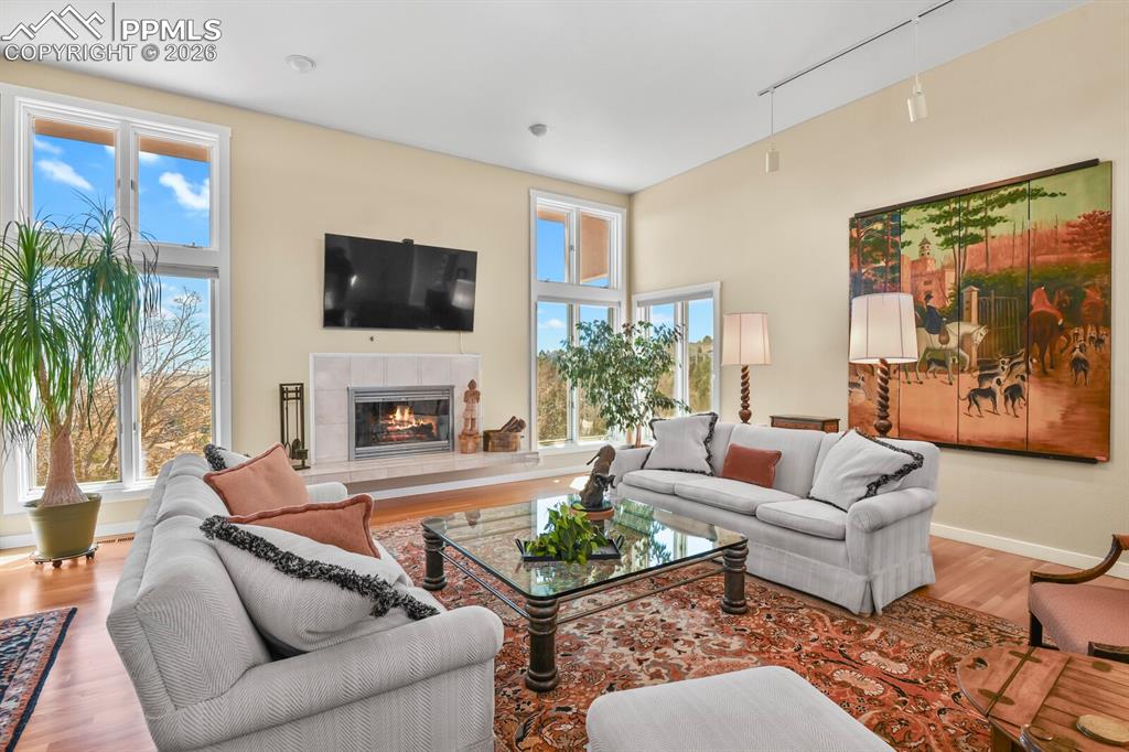 Image 9 of 50: Living room with hardwood floors, wood burning fireplace and neutral surrou