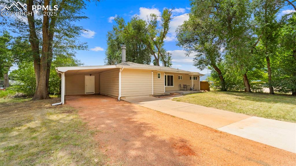 Image 2 of 37: Home surrounded by mature trees providing shade and privacy