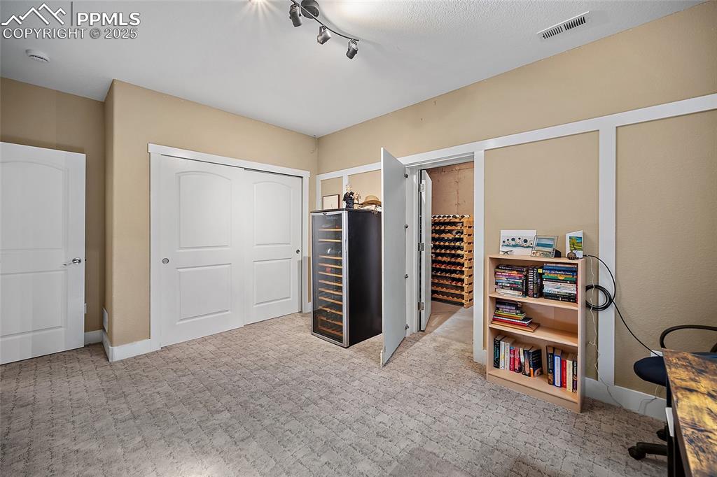 Image 33 of 47: Bedroom/office with wine vault