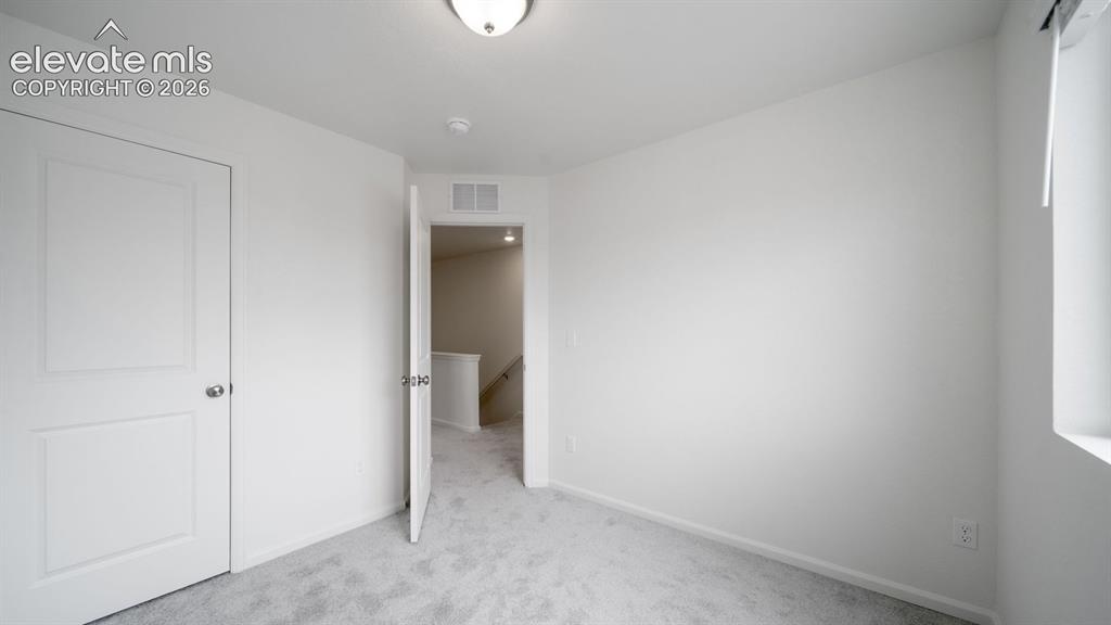 Image 11 of 36: Carpeted room with white walls, a flush-mount ceiling light fixture, and a 