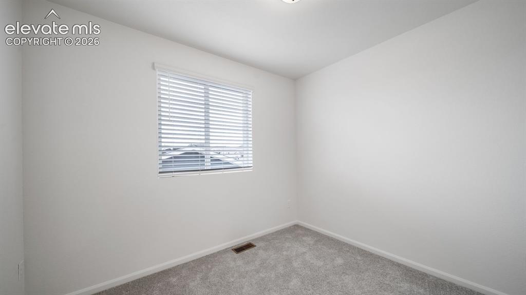 Image 12 of 36: Carpeted room featuring a single window with blinds, white walls, and a cei