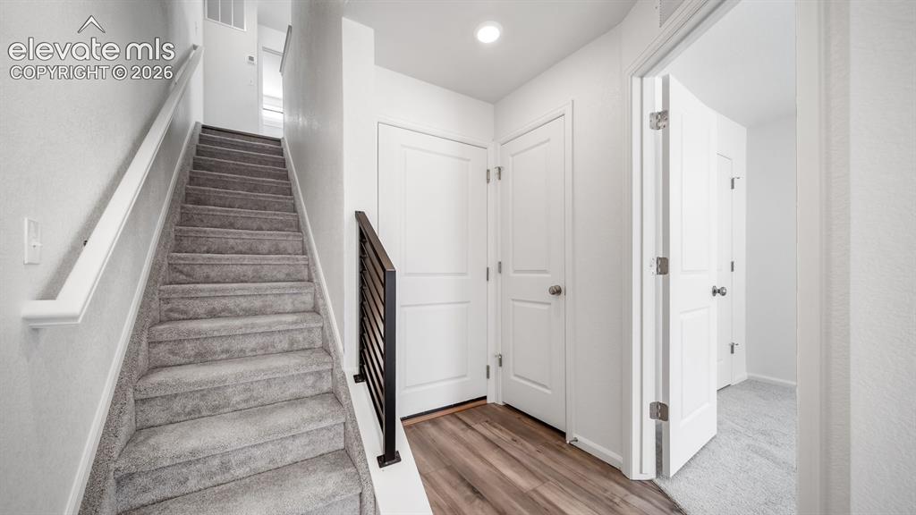 Image 16 of 36: Staircase with gray carpeting and a contemporary black metal baluster
*Pho