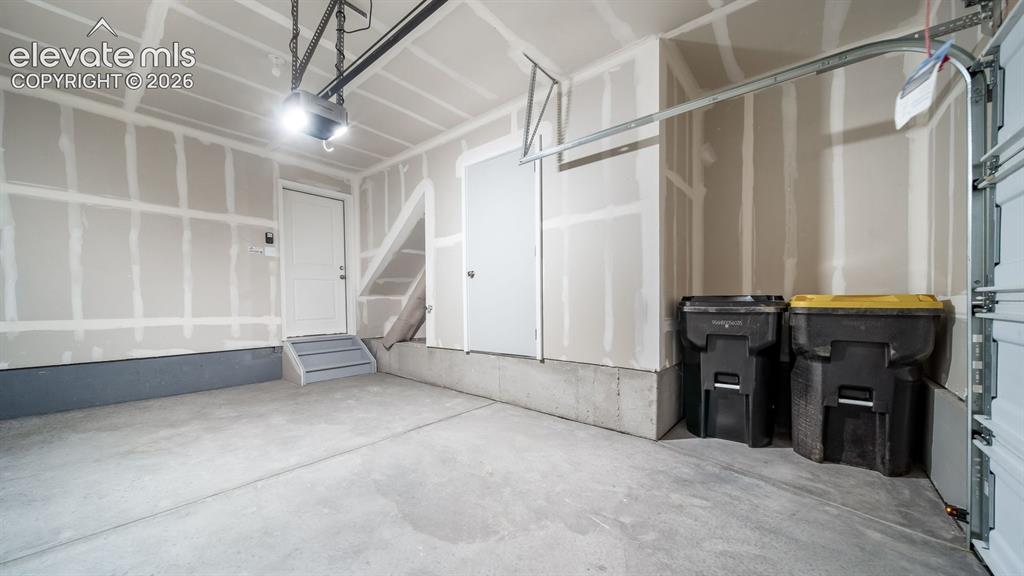 Image 18 of 36: Attached garage featuring a concrete floor, an overhead door with an automa