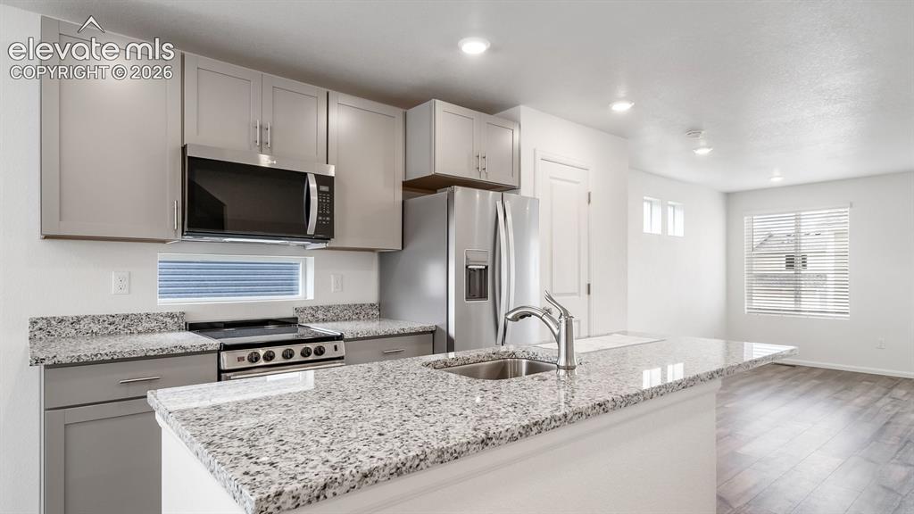 Image 19 of 36: Modern kitchen featuring light gray cabinetry, stainless steel appliances, 