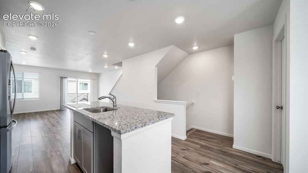 Image 21 of 36: Kitchen island featuring a stainless steel sink, gooseneck faucet, and gran