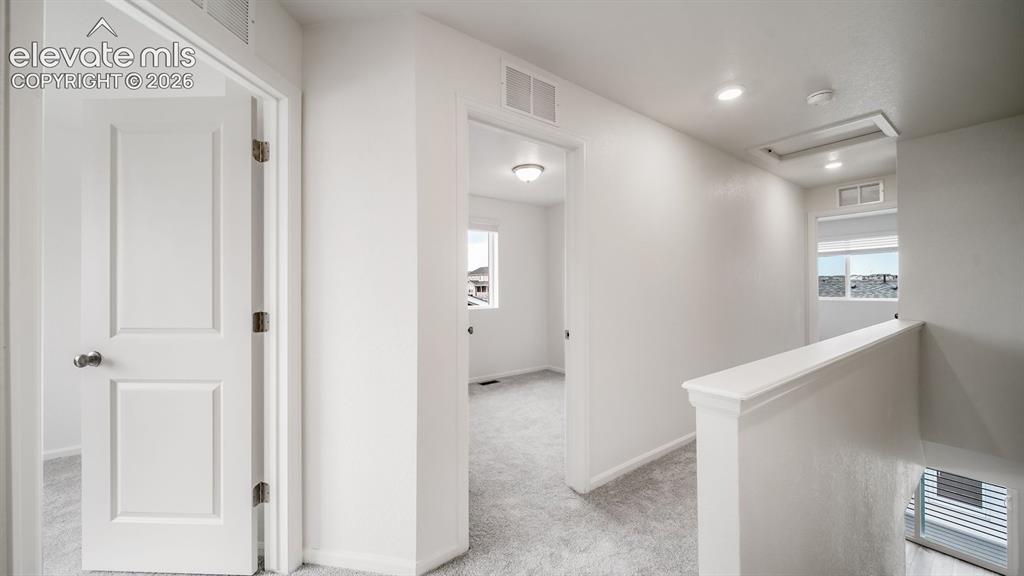 Image 23 of 36: Hallway featuring light gray carpet, recessed lighting, white walls, and wh