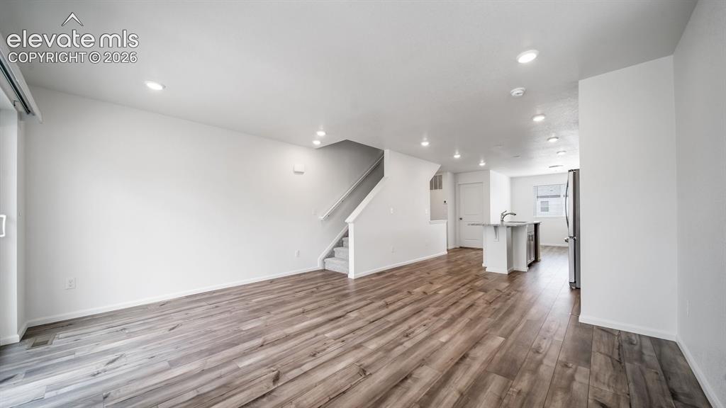 Image 26 of 36: Open-concept living space featuring wood-finish flooring, recessed lighting