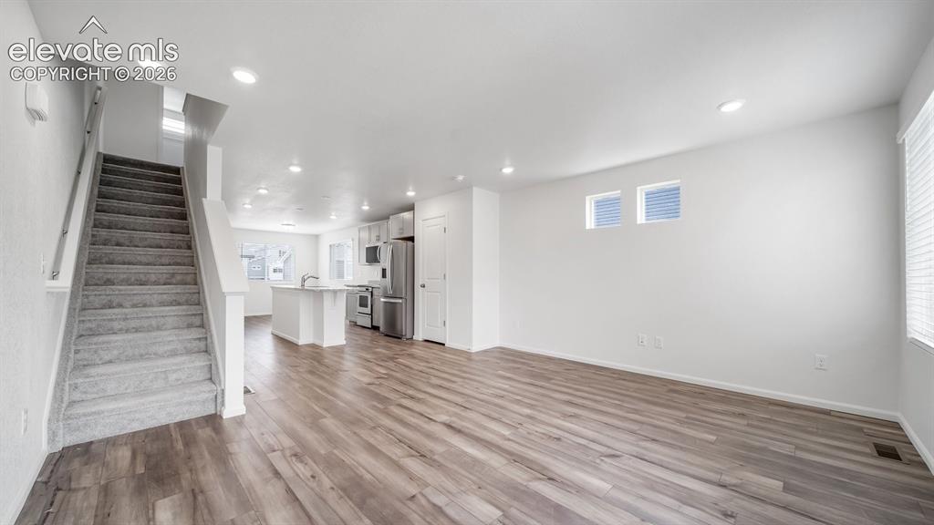 Image 27 of 36: Open-concept living space featuring wood-finish flooring, recessed lighting
