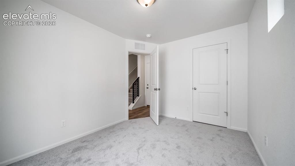 Image 29 of 36: Carpeted room featuring white walls, a flush-mount ceiling light, and a whi