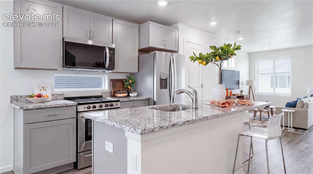 Image 3 of 36: Modern kitchen featuring light gray cabinetry, stainless steel appliances, 