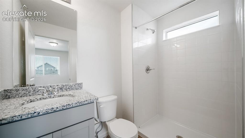 Image 31 of 36: Bathroom featuring a light-toned vanity with a stone countertop, an undermo