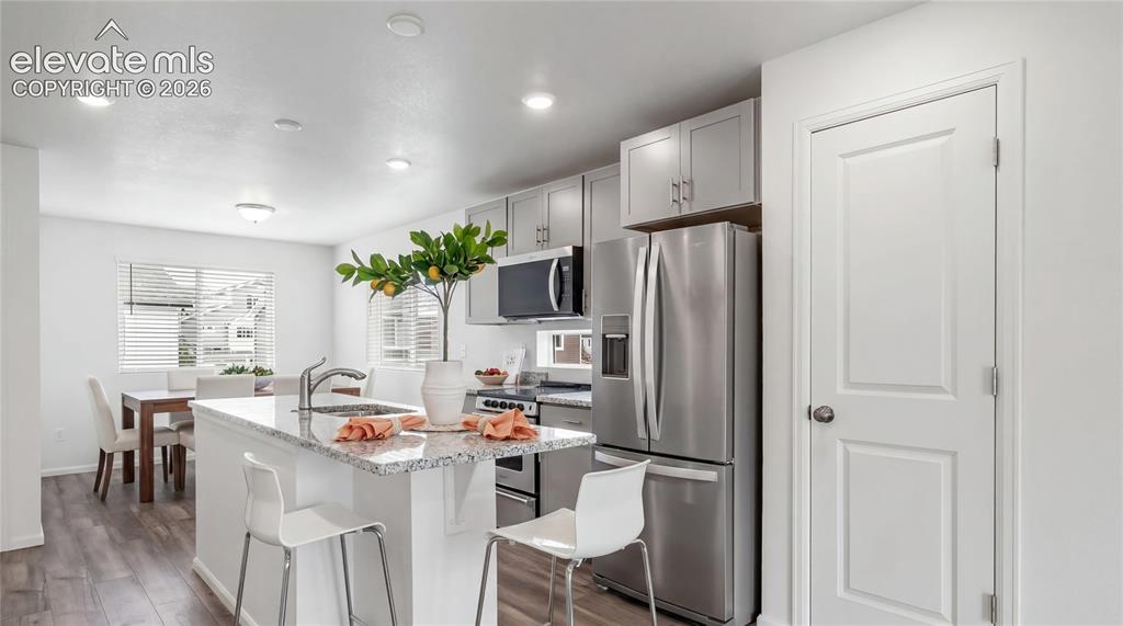 Image 4 of 36: Kitchen island featuring a single-basin sink and a light-colored speckled c