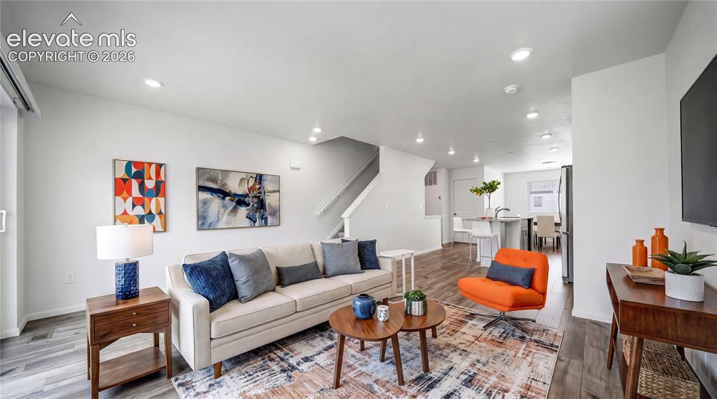 Image 5 of 36: Open-concept living area featuring light-toned walls, recessed lighting, an