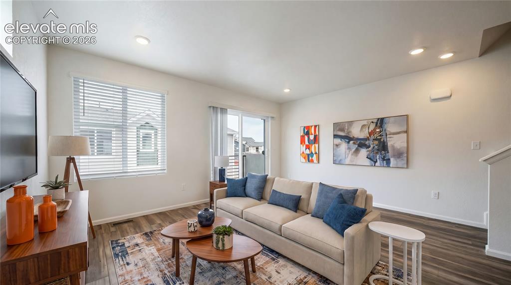 Image 6 of 36: Open-concept living area featuring wood-finish flooring, recessed lighting,