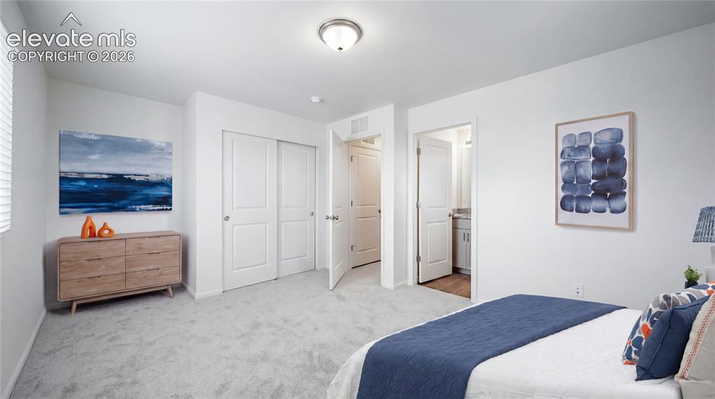 Image 7 of 36: Wall-to-wall carpeting and white walls in a bedroom featuring a double-door