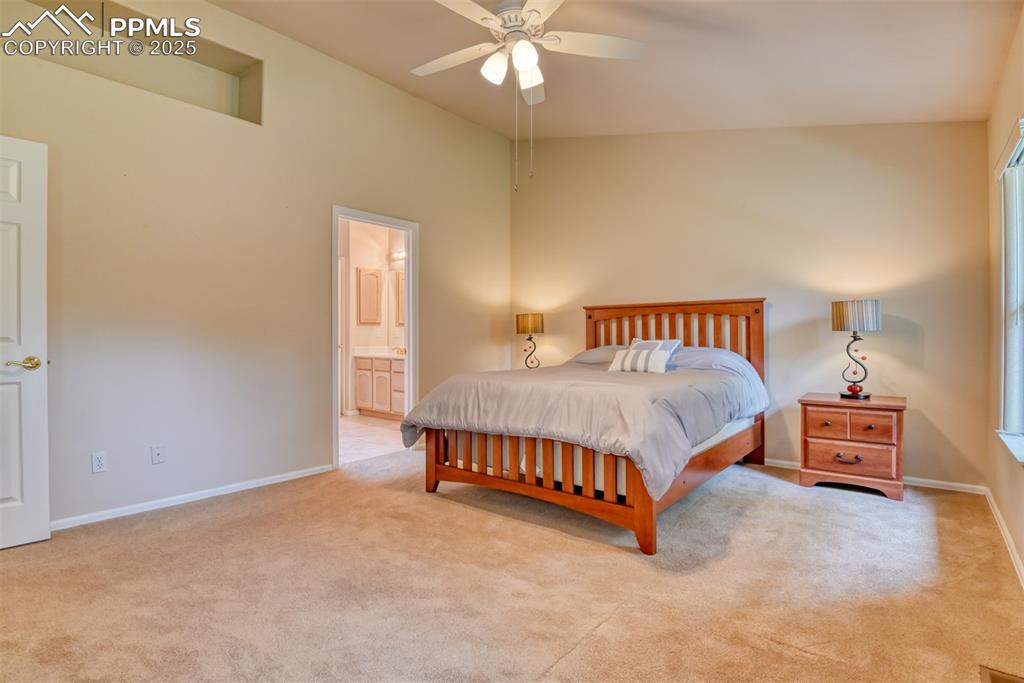Image 23 of 37: Bedroom featuring light carpet, a ceiling fan, and connected bathroom