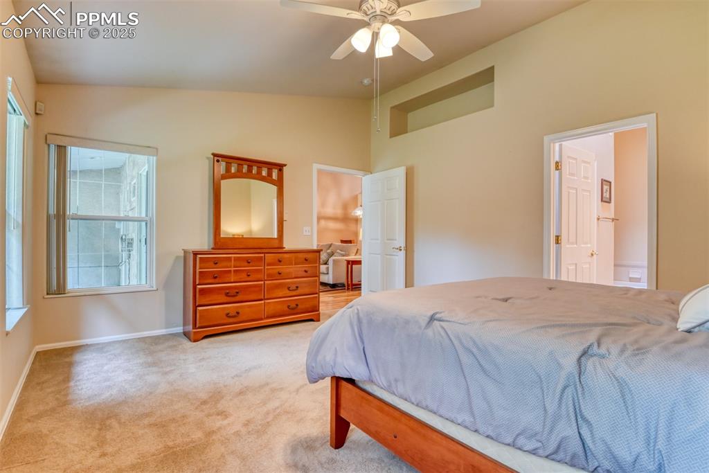 Image 24 of 37: Bedroom featuring light carpet, lofted ceiling, a ceiling fan, and connecte