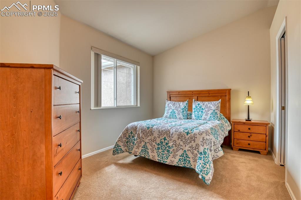 Image 29 of 37: Bedroom featuring vaulted ceiling and light carpet