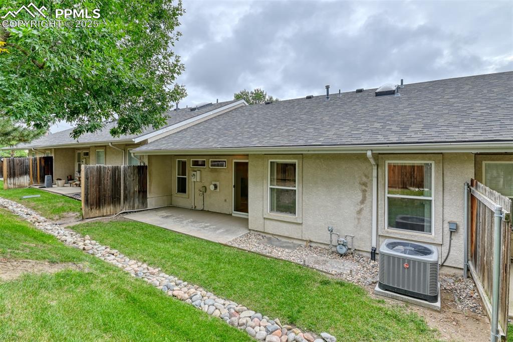 Image 3 of 37: Rear view of house featuring a patio area, a shingled roof, and stucco sidi
