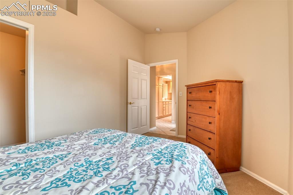 Image 31 of 37: Bedroom with light colored carpet and baseboards