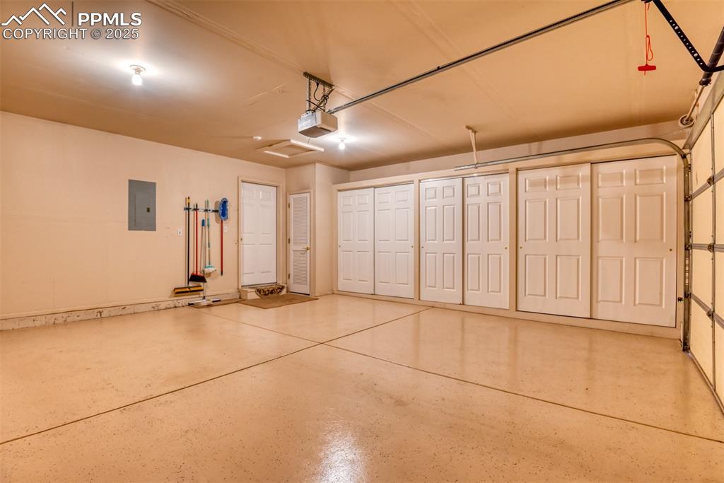 Image 36 of 37: Garage with electric panel and a garage door opener
