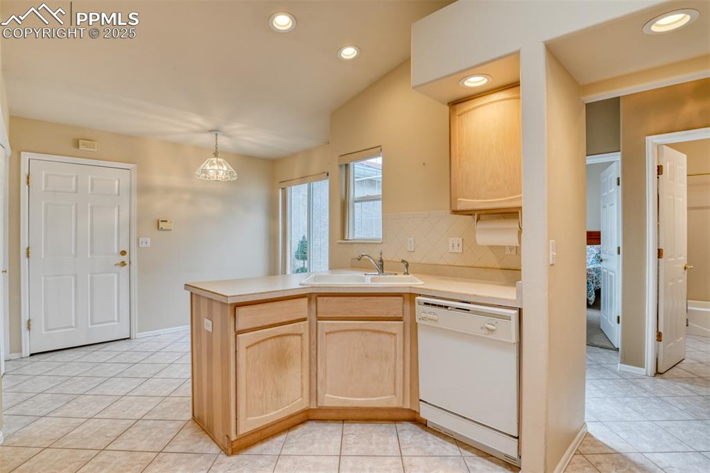 Image 6 of 37: Kitchen with light brown cabinets, light countertops, white dishwasher, rec
