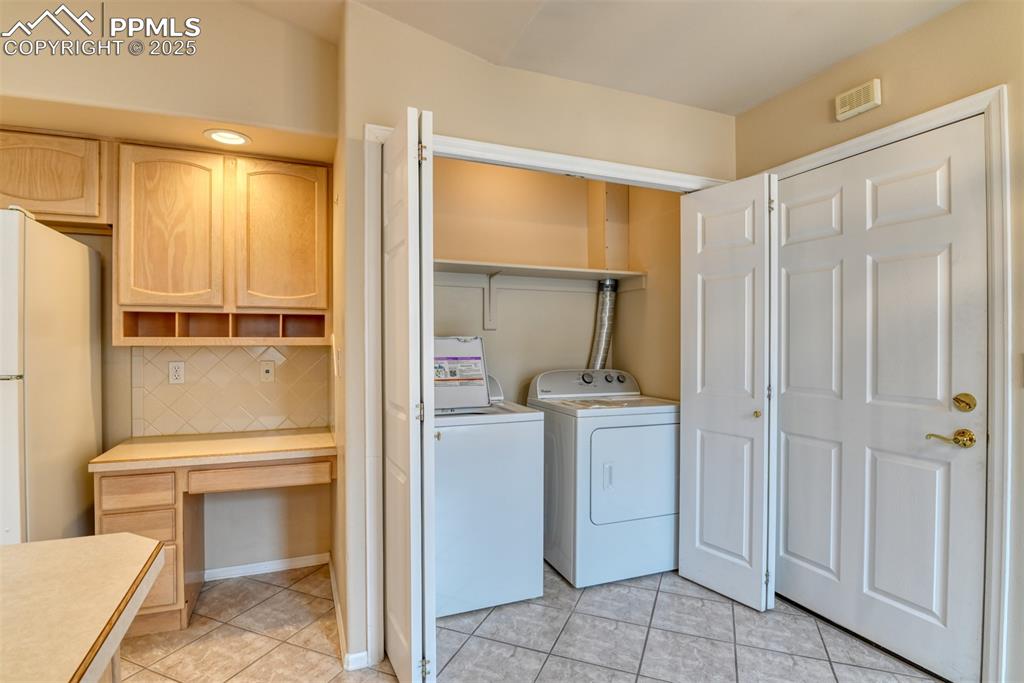 Image 8 of 37: Laundry room featuring light tile patterned floors, an office area, and was