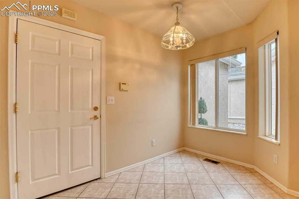 Image 9 of 37: Foyer with light tile patterned flooring and a chandelier