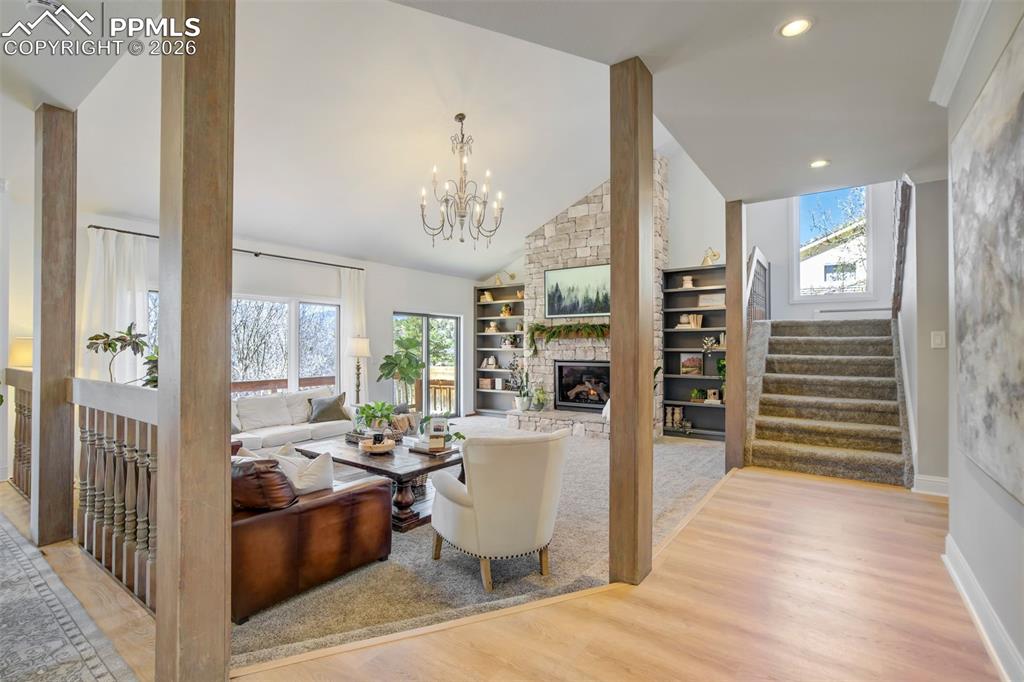 Image 10 of 49: Great room featuring a floor to ceiling stone fireplace and vaulted ceiling