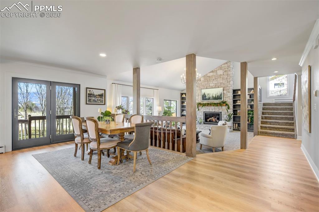 Image 11 of 49: Dining area with light wood-type flooring, a fireplace, and recessed lighti