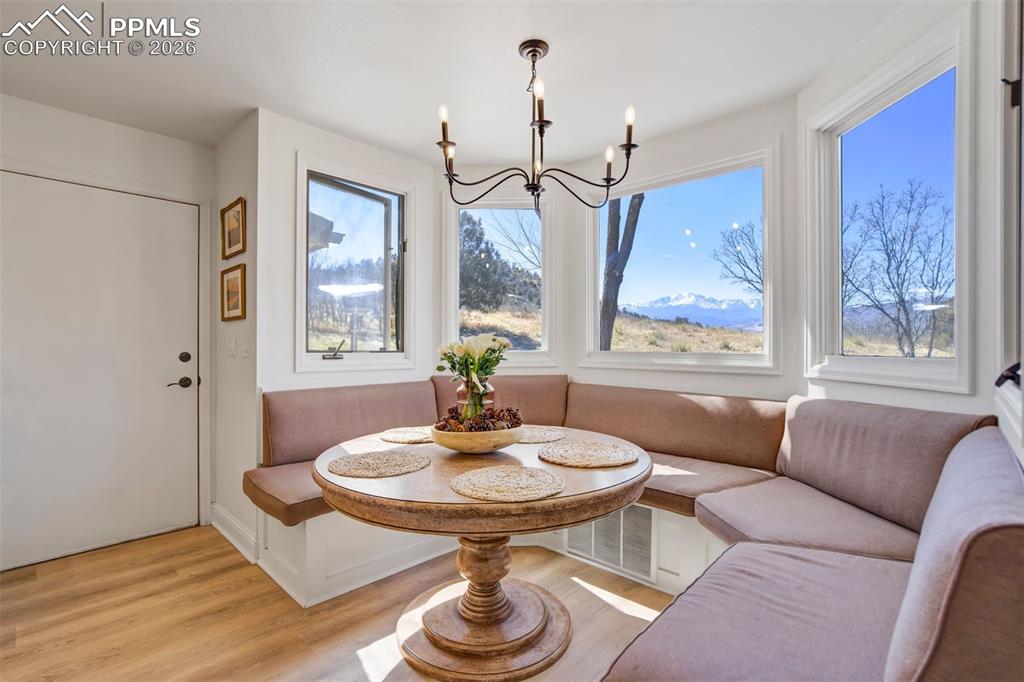 Image 20 of 49: Dining area with breakfast area, light wood-type flooring, and hanging ligh