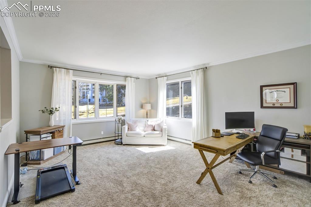 Image 23 of 49: Carpeted home office with ornamental molding, a baseboard radiator, and hea
