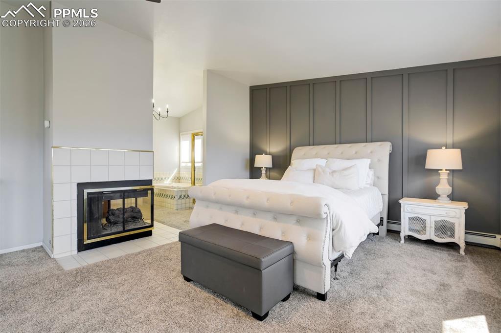 Image 27 of 49: Primary bedroom with ensuite bath, fireplace, deck with view, and walk-in c