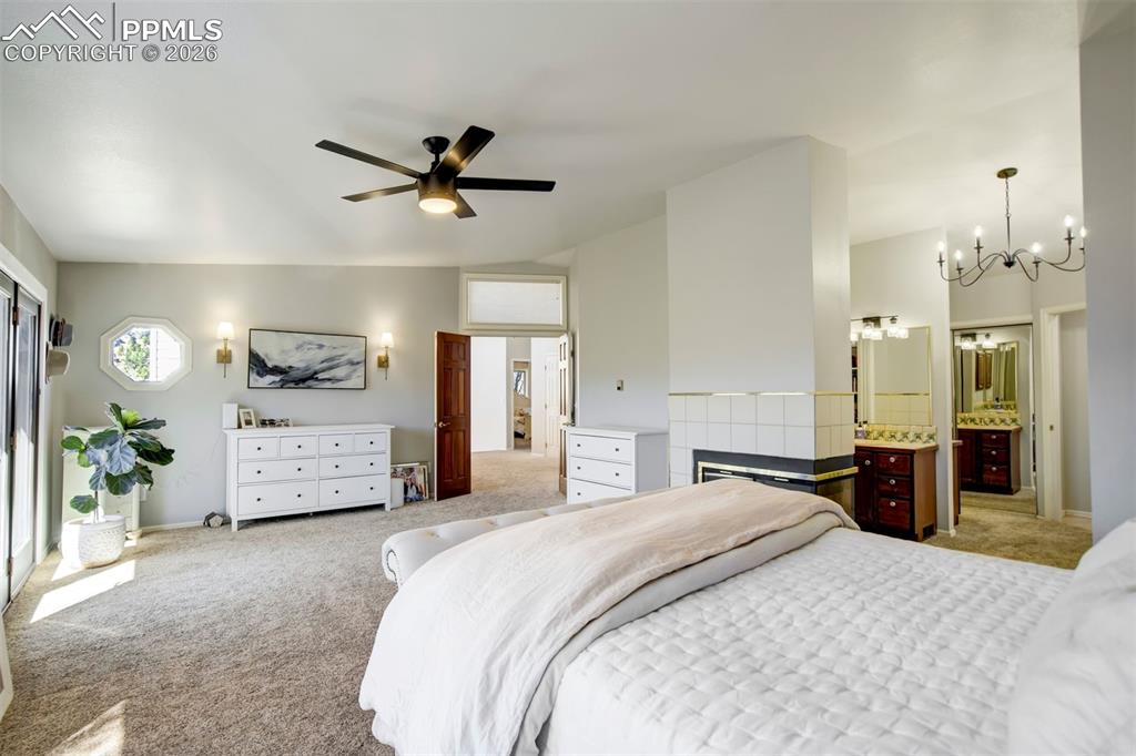 Image 28 of 49: Primary bedroom with ensuite bath, fireplace, deck with view, and walk-in c