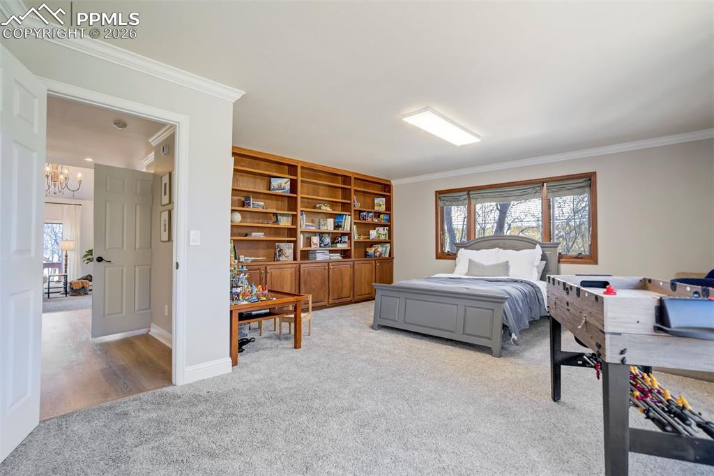 Image 31 of 49: Large Main level bedroom #1 with built in shelves and bookcases