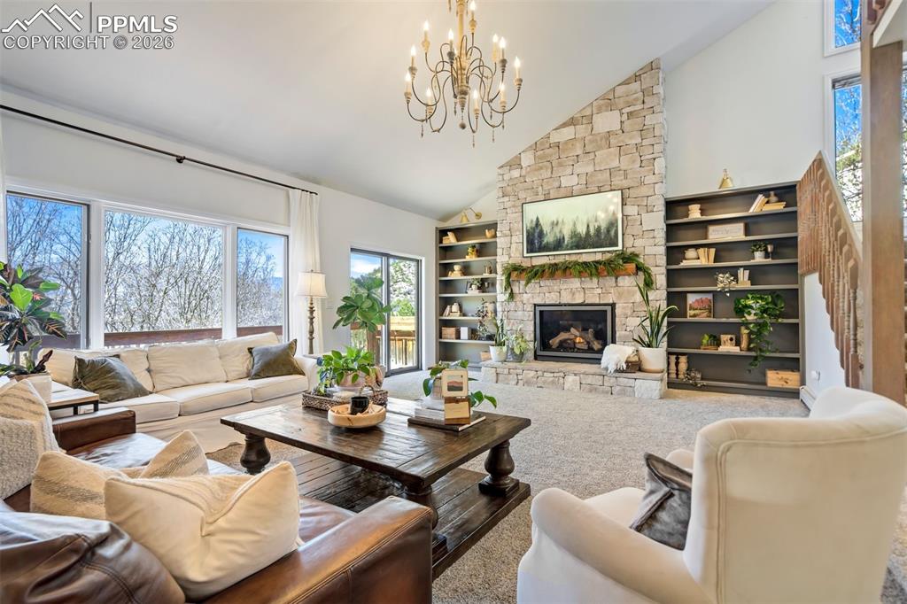 Image 7 of 49: Great room featuring a floor to ceiling stone fireplace and vaulted ceiling