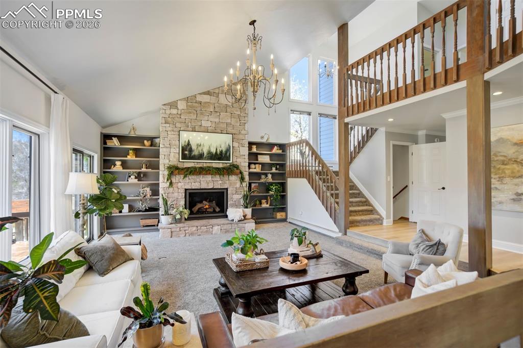 Image 8 of 49: Great room featuring a floor to ceiling stone fireplace and vaulted ceiling
