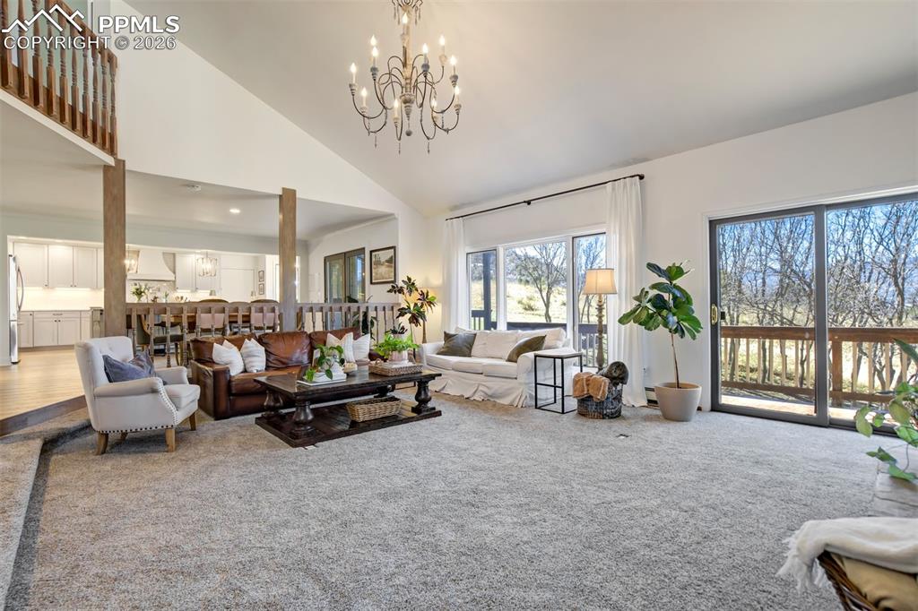 Image 9 of 49: Great room featuring a floor to ceiling stone fireplace and vaulted ceiling