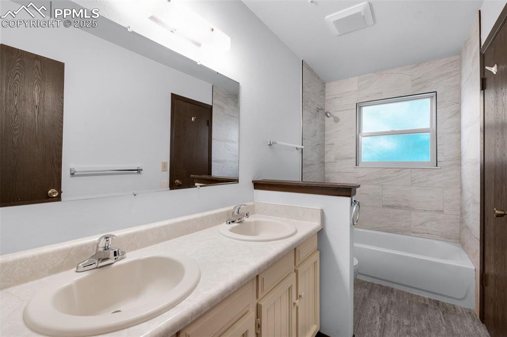 Image 18 of 49: Full bath with double vanity and redone floor and bath tile.