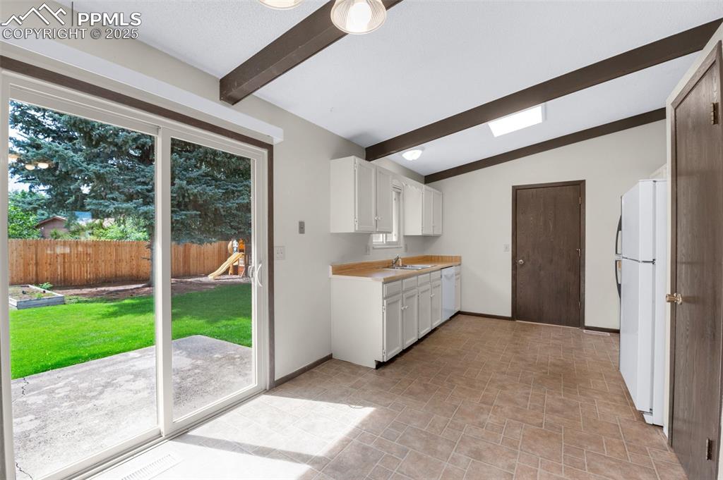 Image 8 of 49: Glass doors in kitchen leading to large patio and back yard.
