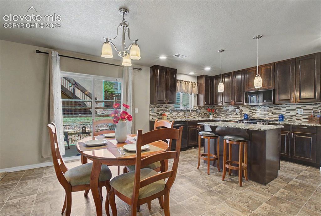 Image 10 of 42: Dining Area/Kitchen w/ Walkout to Backyard