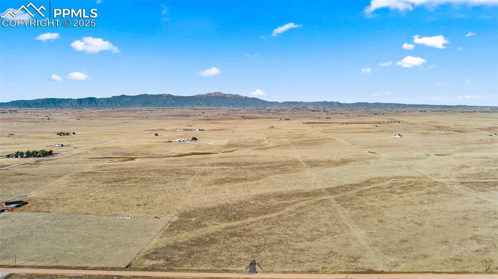 Image 7 of 19: Aerial view of sparsely populated area featuring a desert landscape and a m