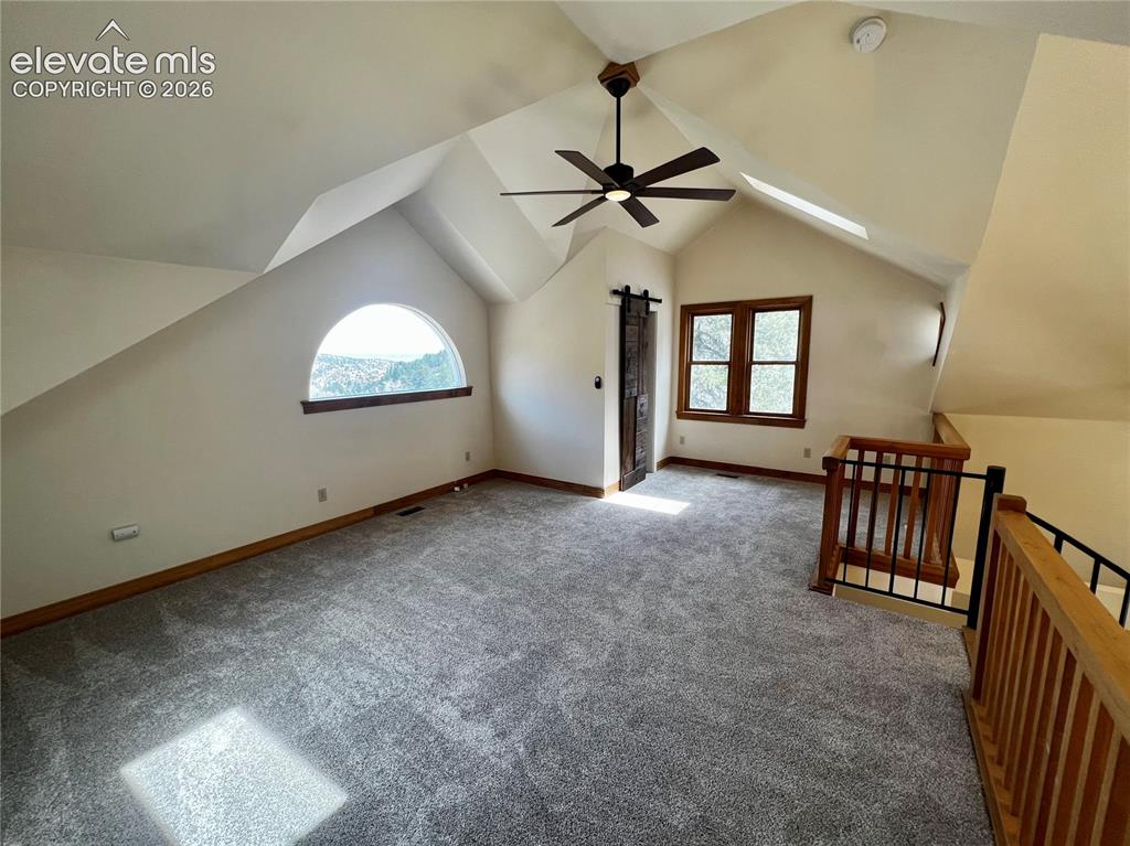 Image 18 of 45: Custom Cottage: Loft bedroom with walk-in closet and spiral staircase